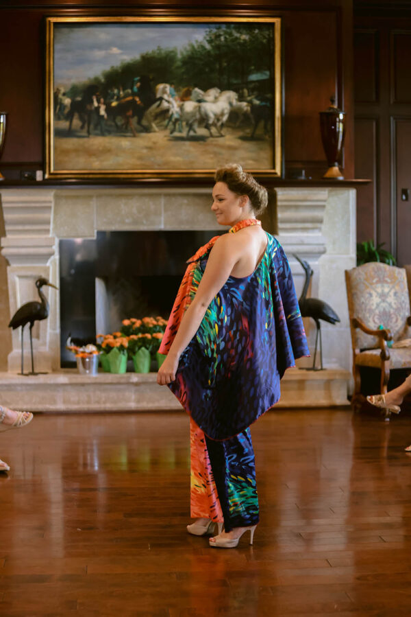 A woman in an orange and blue dress standing on the floor.