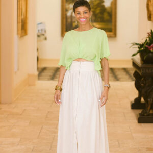 A woman in a lime green top and white skirt.