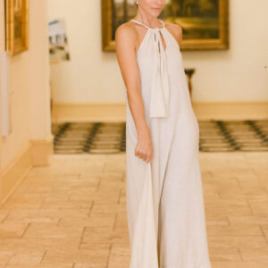 A woman in white dress standing on tiled floor.