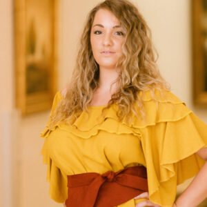 A woman in yellow shirt and red belt