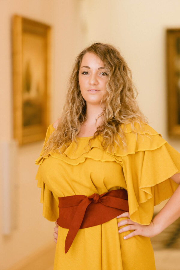 A woman in yellow shirt and red belt