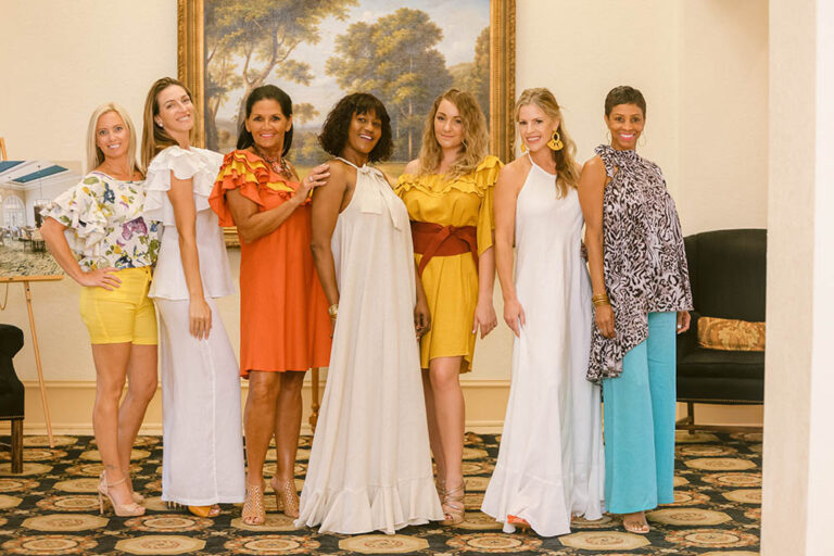 A group of women in different dresses posing for the camera.