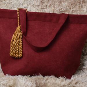 A red purse with a gold tassel hanging from the handle.