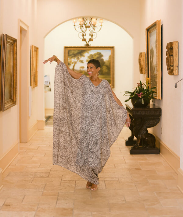 A woman in a long dress is walking down the hall way