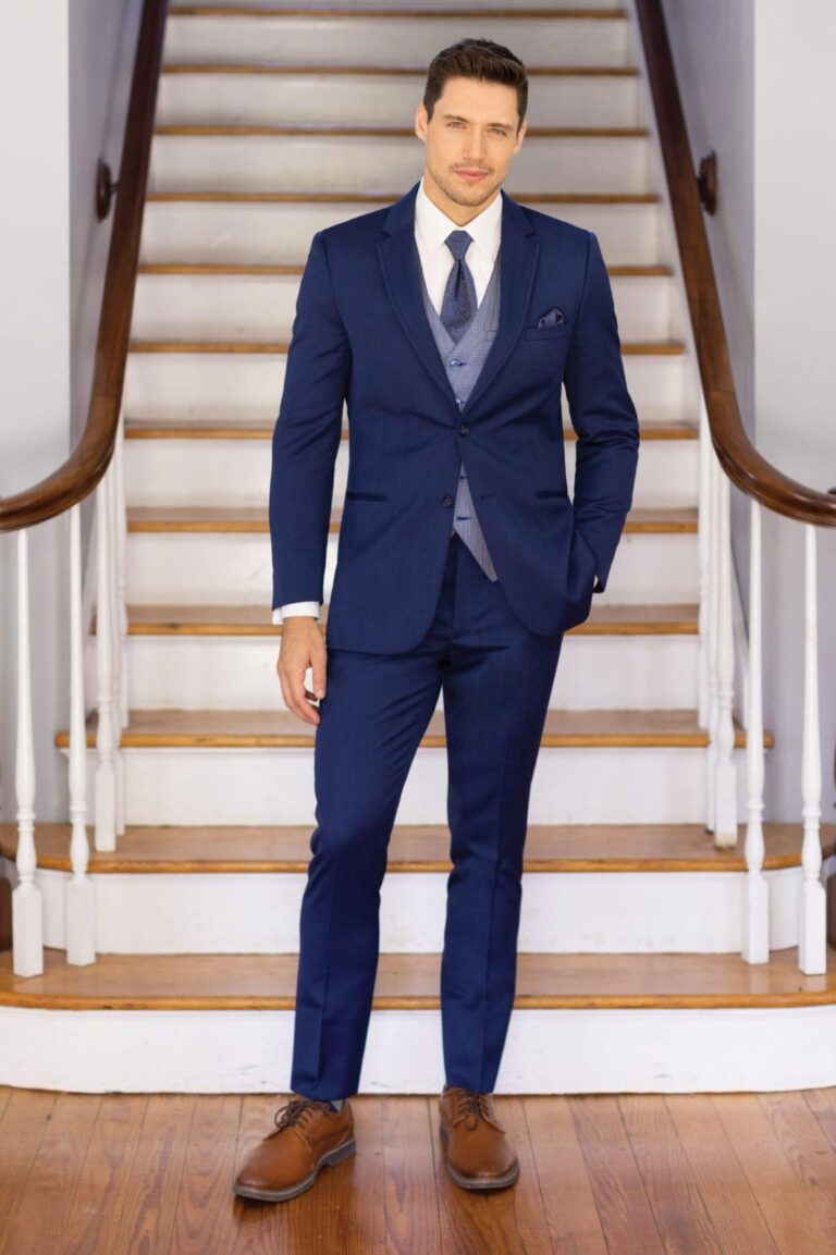 A man in a suit standing on top of stairs.