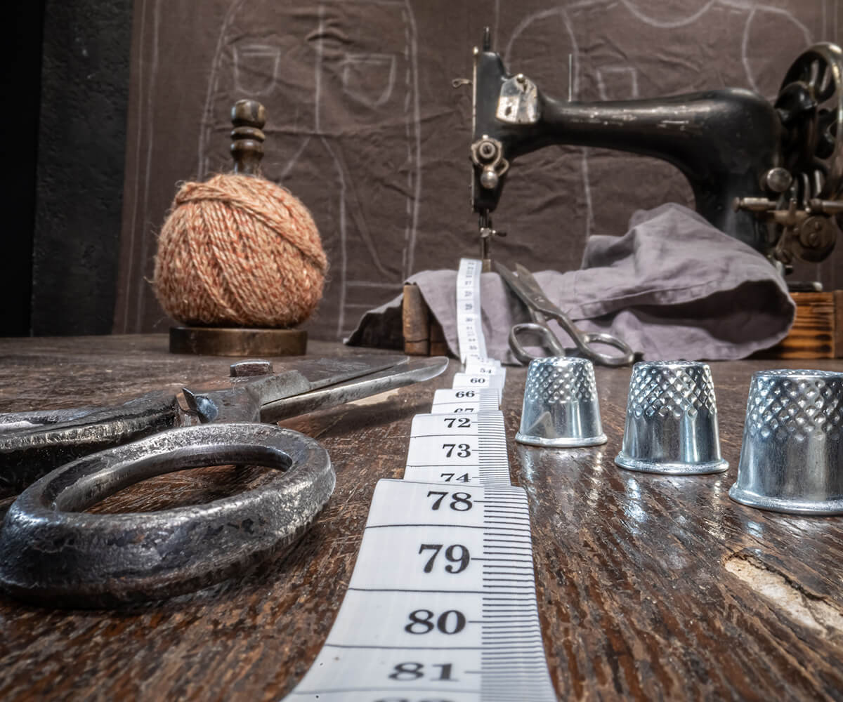 A table with sewing equipment and thimbles on it.